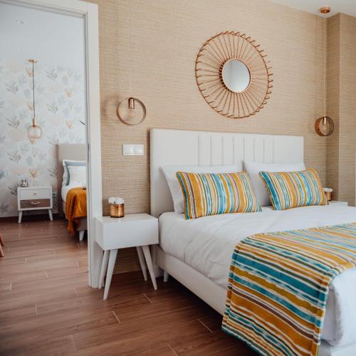 a bedroom with a white bed and a mirror at Yellow Sweet Home - Maria e Beatriz in Nazaré