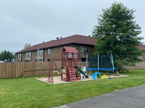 een speeltuin in een tuin naast een huis bij Lakeshore Suites in North Bay