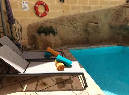 basen z ławką obok basenu w obiekcie Ta Marie Merhba w mieście Żebbuġ
