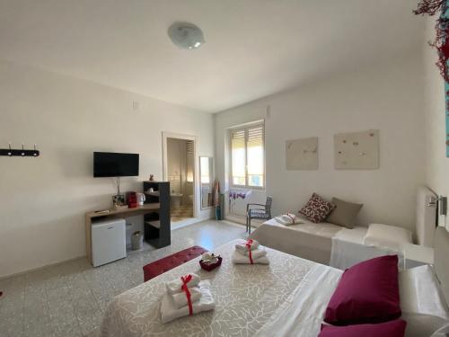 a white living room with a couch and a table at Rossocorallo Rooms in Alghero