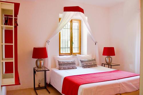 een slaapkamer met een bed met 2 lampen en een raam bij Villa Fonti in Orciano di Pesaro