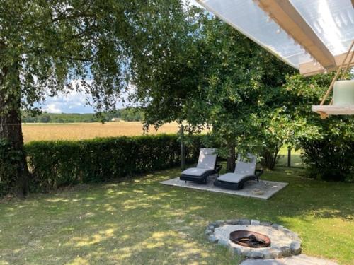 un patio con 2 sillas y una hoguera en Apartment "Stine" en Erpen