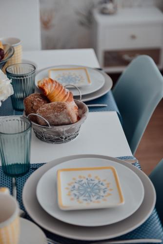 a table with plates of food and a bowl of bread at Yellow Sweet Home - Maria e Beatriz in Nazaré