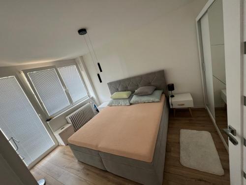 a bedroom with a large bed and two windows at -Self-check- brand new apartment White-Diamond in Nitra