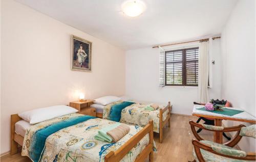 um quarto com 2 camas, uma mesa e uma janela em Beautiful Home In Lovran With House Sea View em Lovran