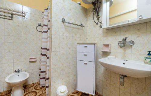 y baño con lavabo, aseo y espejo. en Beautiful Home In Lovran With House Sea View, en Lovran