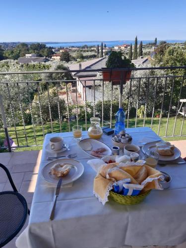 einen weißen Tisch mit Essen auf dem Balkon in der Unterkunft Ladi’s B&B in Bardolino