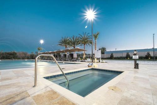a swimming pool in a resort with palm trees at Cozy Home Resort Community Disney 5 Min in Orlando