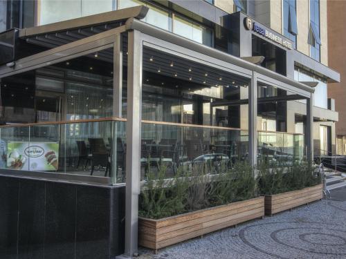 a restaurant with glass doors and plants in front of a building at Fesa Business Hotel in Gebze