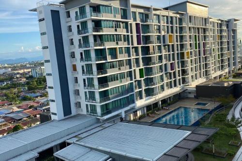 a large building with a swimming pool in front of it at #1.3 Cozy 7Pax Large Beds 2B1R Vivacity Kuching Jazz Suites in Kuching