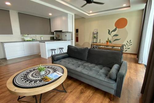 a living room with a couch and a table at #1.3 Cozy 7Pax Large Beds 2B1R Vivacity Kuching Jazz Suites in Kuching