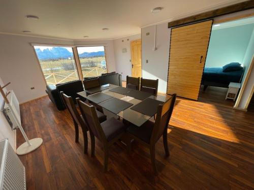 comedor con mesa, sillas y sofá en Departamentos 8va Maravilla en Torres del Paine