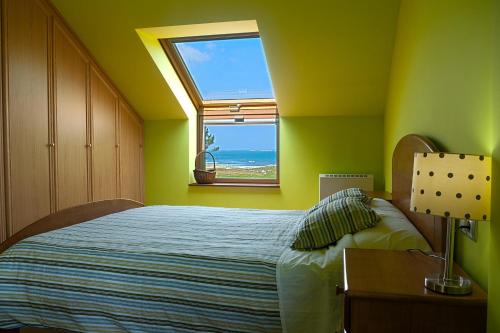 a bedroom with a bed with a view of the ocean at Lar Atlantis in Basoñas