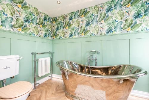 斯旺西的住宿－The Caswell bay hide out，带浴缸的浴室和蓝色的墙壁