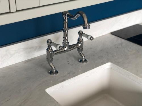 a kitchen sink with a faucet on a counter at The Caswell bay hide out in Swansea