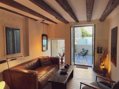 uma sala de estar com um sofá de couro e uma mesa em Spacious 2br in Arles Historical Center With Terrace em Arles
