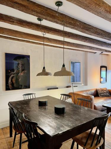 un salon avec une table, des chaises et un canapé dans l'établissement Spacious 2br in Arles Historical Center With Terrace, à Arles