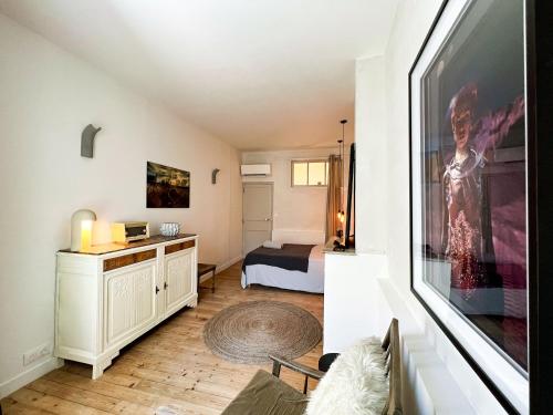 uma sala de estar com uma cama e uma grande pintura na parede em Spacious 2br in Arles Historical Center With Terrace em Arles