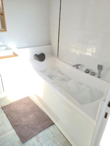 uma banheira branca na casa de banho com um tapete em 20 min de Disneyland - 4 chambres - 30 min Paris em Thorigny-sur-Marne
