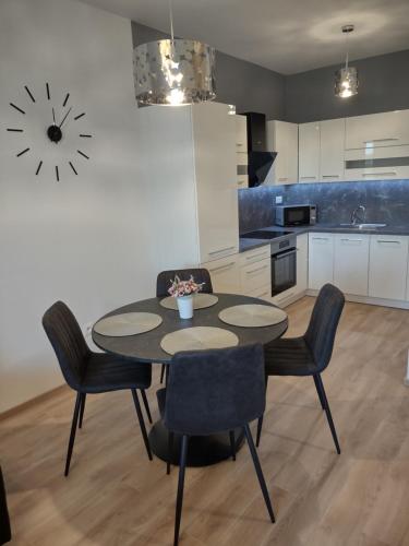 a kitchen with a table and chairs in a room at KARINA APARTMAN in Dunajská Streda