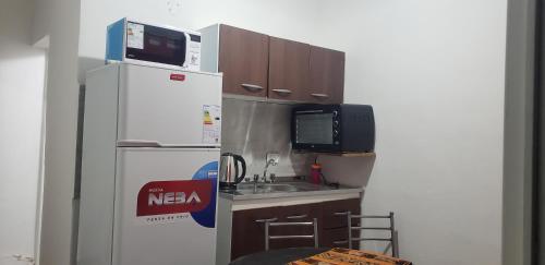 una pequeña cocina con refrigerador y fregadero en Vientos del Sur en La Rioja