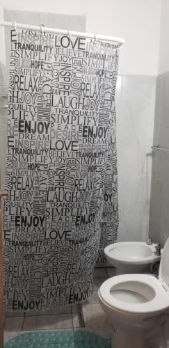 y baño con cortina de ducha y aseo. en Vientos del Sur, en La Rioja