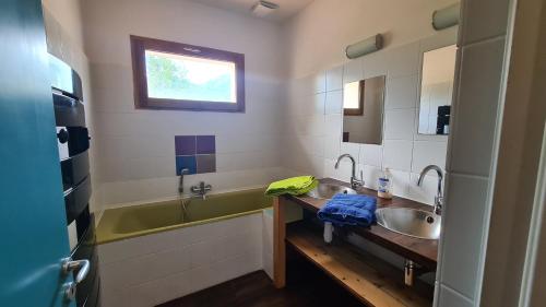 a bathroom with two sinks and a tub and a window at Villa Levier in Carbuccia