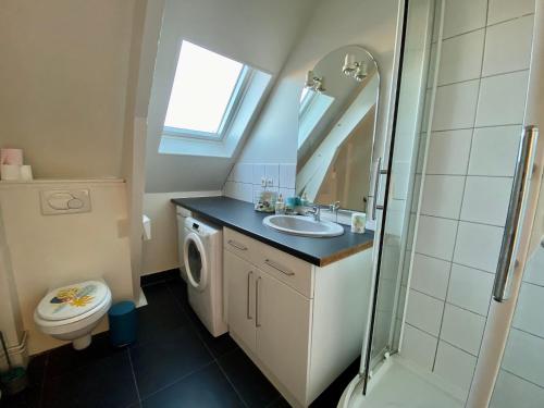 La salle de bains est pourvue d'un lavabo et d'un lave-linge. dans l'établissement Appartement T4 place voltaire - 016, à Saint-Sever