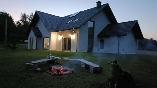 a house with a fire in front of it at Dom nad Rzeką in Raciechowice