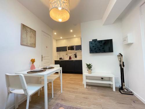 une cuisine et une salle à manger avec une table et des chaises blanches dans l'établissement Nice Renting - FERSEN - 2 Rooms Vieil Antibes - AC - Safranier - Big Terrace, à Antibes