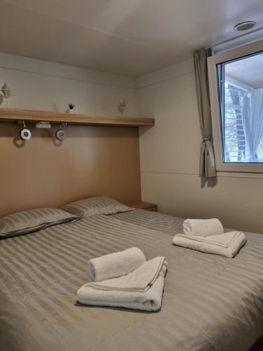 a bedroom with two beds with towels on them at Premium Mobile Home ZEN SPOT 279 in Jezera