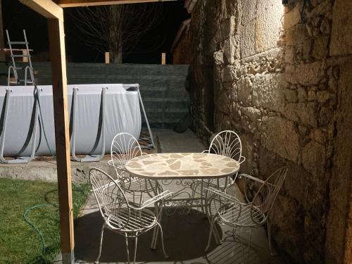 une table et des chaises assises sur une terrasse dans l'établissement Casa do Miguelo Costa da Morte, à La Corogne
