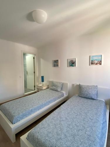 een slaapkamer met 2 bedden en een spiegel bij Suites Setúbal - River View in Setúbal
