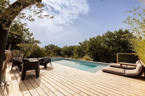 een terras met stoelen en een zwembad bij Villa Parenthèse in Saint Alban Auriolles