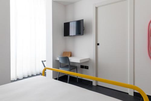 een slaapkamer met een bed, een bureau en een televisie bij AMARENA B&B Porto Recanati in Porto Recanati
