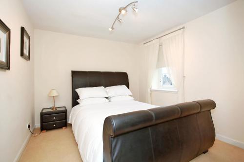 a bedroom with a large bed with a leather headboard at Fonthill Apartments in Aberdeen