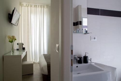 bagno con vasca bianca e lavandino di Relais Merulana Guest House a Roma