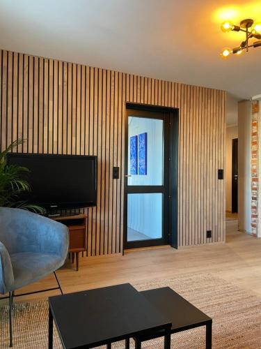 a living room with a couch and a television at Nice apartment close to the sea with parking and garden in Arendal