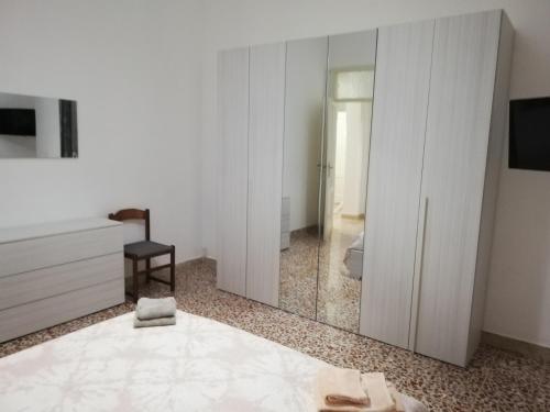 Habitación blanca con puerta corredera de cristal en Alle Falde di Erice, en Trapani