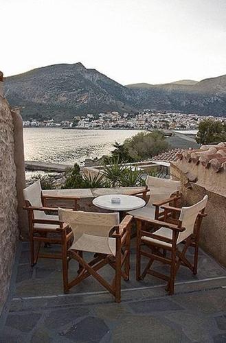 a table and chairs on a balcony with a view of the water at Lazareto Hotel in Monemvasia