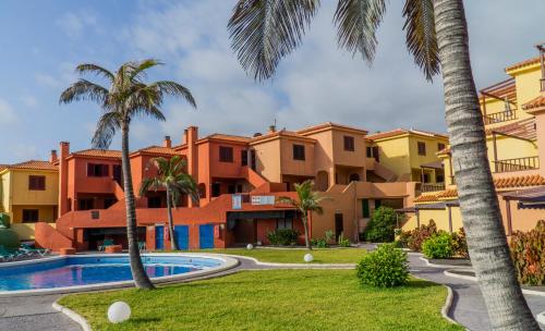 a resort with a swimming pool and palm trees at Apartamentos TAMARAGUA in Breña Baja