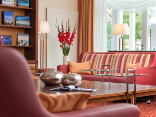 a living room with a couch and a coffee table at A-ROSA Ostseehotel Kühlungsborn in Kühlungsborn