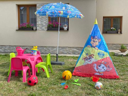 a childs play area with a table and an umbrella at Chalupa pod Tatrami in Liptovská Teplička