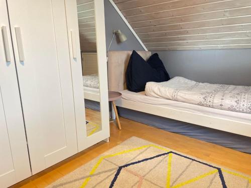 a small bedroom with a bunk bed and a mirror at Modern house with office possibilities in Stavanger
