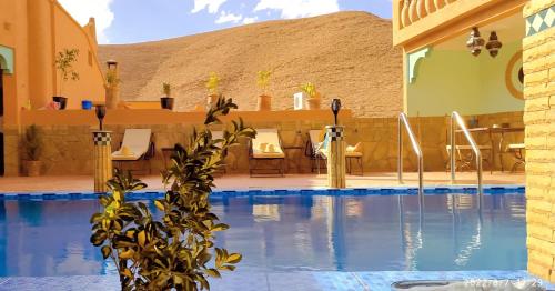 a resort with a swimming pool with a table and chairs at Dar Ahlam Dades in Aït Ouaddar