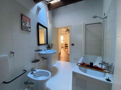 ein Badezimmer mit zwei Waschbecken, einer Badewanne und einem WC in der Unterkunft LHE Beating Heart in Cesena