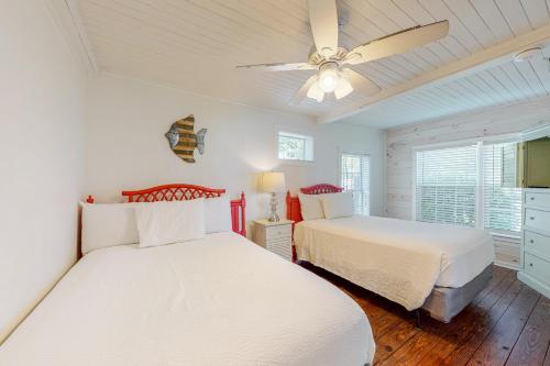 um quarto com 2 camas e uma ventoinha de tecto em Kissing Palms em Panama City Beach