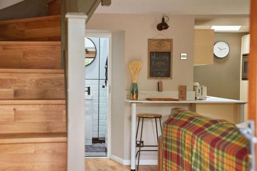 cocina con encimera y mesa con taburete en Crossroads Cottage en Drumnadrochit