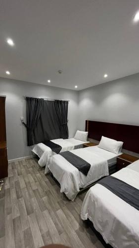 a group of three beds in a room at دانة تاون للوحدات السكنية "يوجد إيجار شهري" in Abha