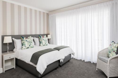 a bedroom with a large bed and a chair at Cape Town Hollow Boutique Hotel in Cape Town
